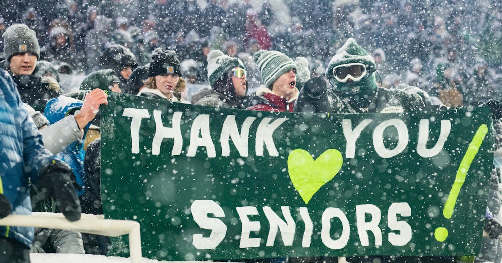 Michigan State fans hold up a sign that says "Thank you seniors" during Michigan State's victory over Penn State on Nov. 27, 2021.