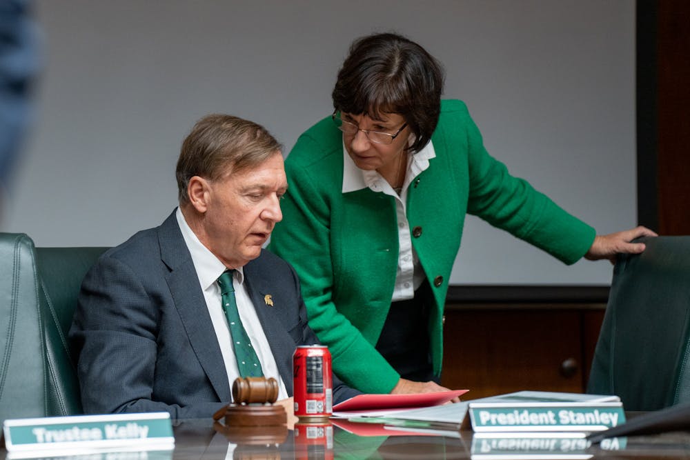 Michigan State University President Samuel L. Stanley talks with Board Chair Dianne Byrum during the Board of Trustees meeting on Oct. 28, 2022.