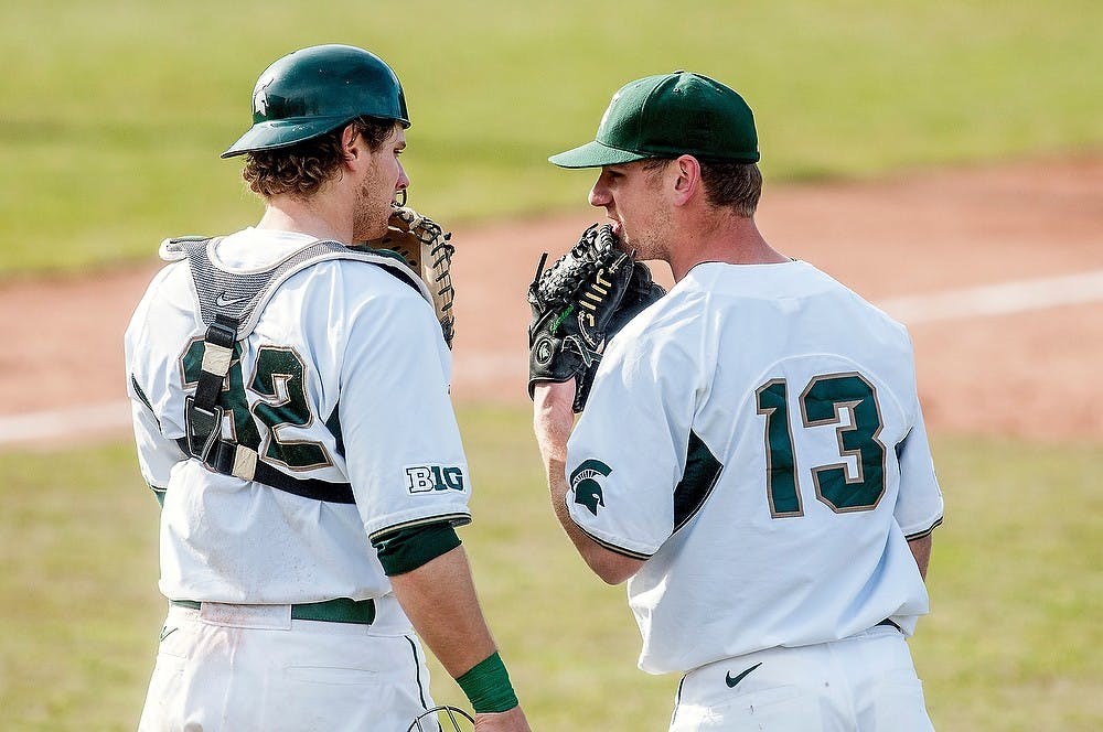 	<p>From left, junior catcher Joel Fisher and freshman right-handed pitcher Justin Alleman talk with one another during a break in play Tuesday at McLane Stadium at Old College Field. The Spartans defeated Toledo, 7-6, after 12 innings of play. Adam Toolin/The State News</p>