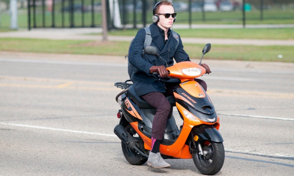 <p>A person rides their moped on Oct. 7, 2015, at the intersection of West Shaw Lane and Chestnut Road.</p>