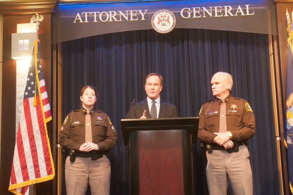 Deputy Amber Hinojosa,left, Attorney General Bill Schuette, and deputy Gene Wrigglesworth address the press on March 14. 2016 at the William Building on 525 W. Ottawa Street in Lansing. Schutte talked about charges for an Ingham county prosecutor.