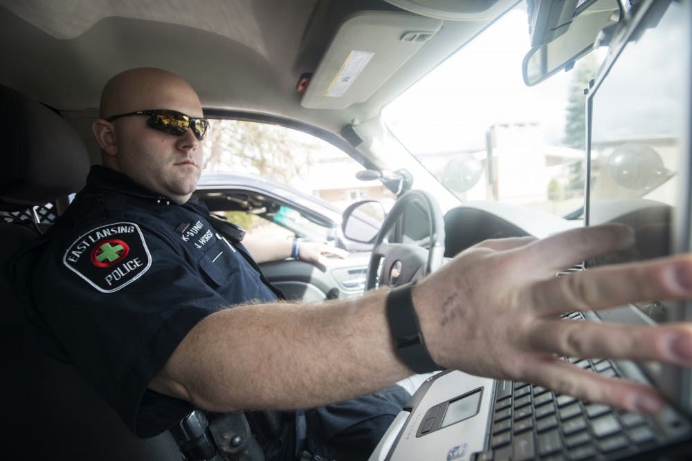 K-9 Patrol Officer Justin Horst uses  his computer inside his police car on March 17, 2016 in East Lansing.  Horst says that officers typically look for disruptive behavior and try to monitor the safety of the city on St. Patrick's Day.