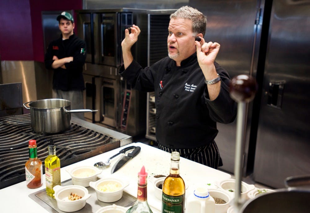 New York City-based chef and Bravo's Top Chef finalist Dave Martin shows the crowd what a truffle looks like during a cooking demonstration of his black truffle macaroni and cheese dish at Brody Square on Wednesday afternoon. The event, hosted by MSU Culinary Services, is the first of celebrity chef demonstrations to be done at the cafeteria. Lauren Wood/The State News