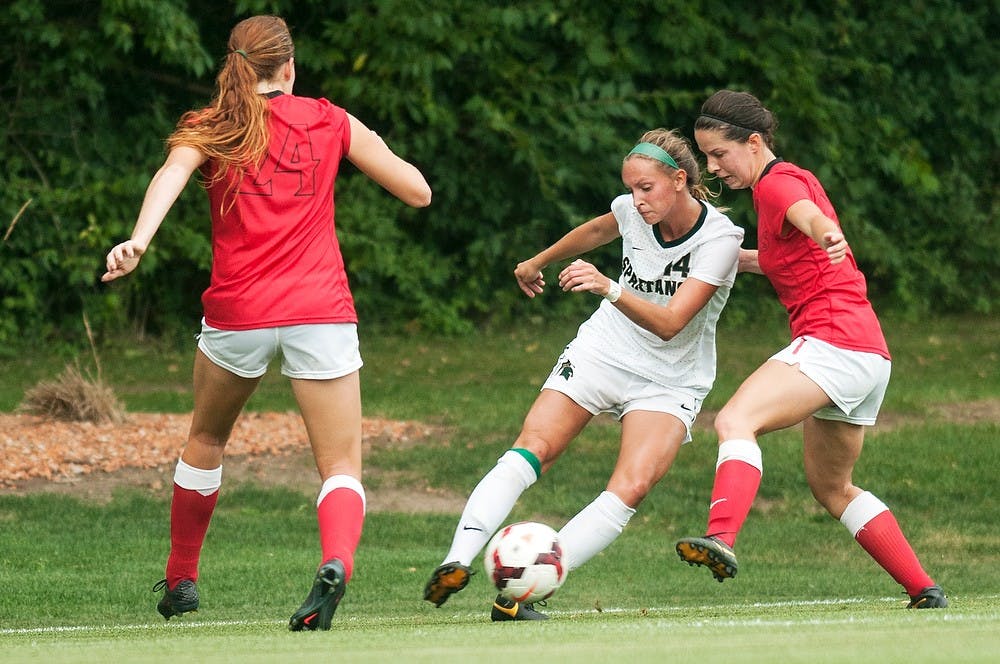 	<p>Junior defender/midfielder Nicole Caruso passes between San Diego State forward Hannah Keane, 24, and forward Haley Locker during the game, Aug. 30, 2013, at DeMartin Soccer Stadium. The Spartans tied with the Aztecs, 1-1. Danyelle Morrow/The State News</p>