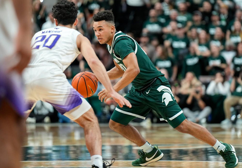 Michigan State junior guard Nick Sanders (20) dribbles the ball during a game against the University of Washington at the Breslin Center in East Lansing, Michigan on January 9, 2025. Michigan State won 88-54.