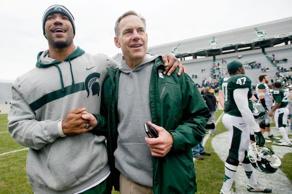 <p>Head coach Mark Dantonio greets former Spartan player Devin Thomas on April 28, 2012, at Spartan Stadium after the conclusion of the annual Spring Green and White Game.</p>