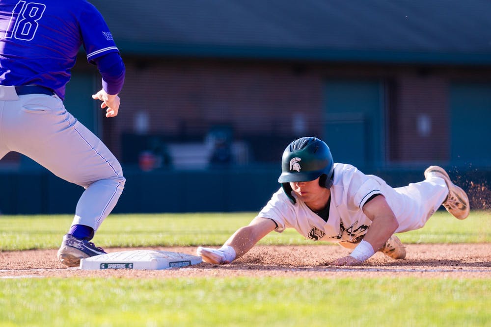 <p>Freshman infielder No. 13 Landen Lozier calmly dives into first base as the pitcher performs a pick-off move during the MSU baseball team’s home opener vs. the University of Evansville at McLane Baseball Stadium on March 15, 2024.</p>