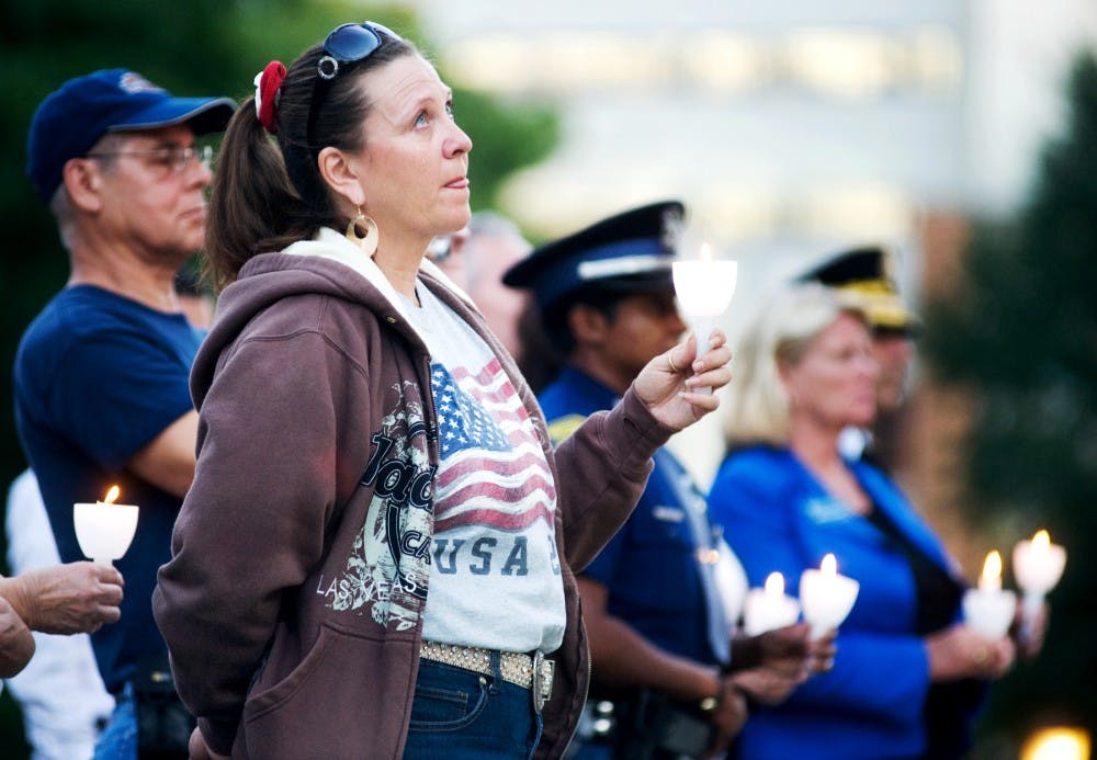 Jodi Hart of Grand Ledge gets emotional as the MacLeod of Lewis Pip Band plays "Amazing Grace" on the bagpipes during the 9/11 Remembrance and Candlelight Vigil at the Capitol building on Sunday, Sept. 11. Lauren Wood/The State News