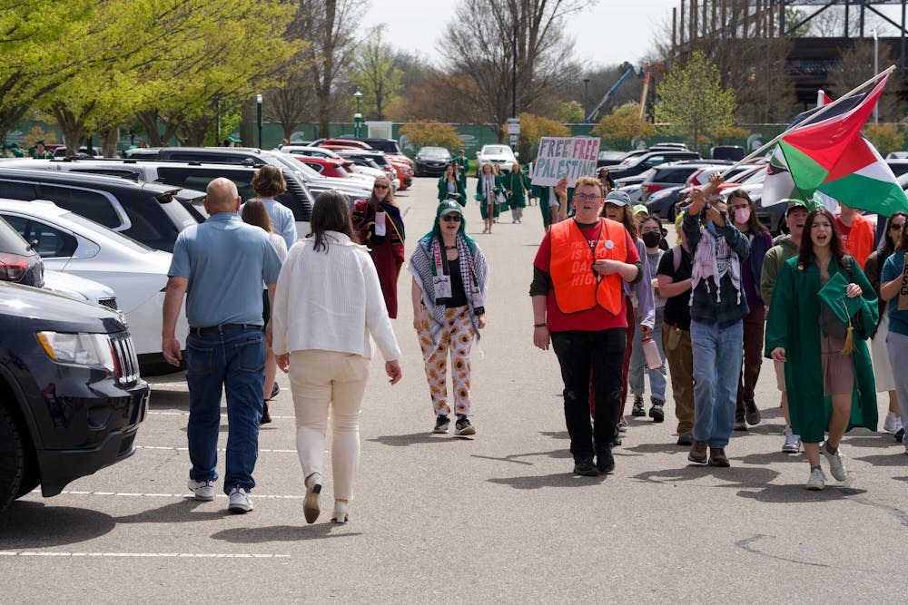 Students protest outside of the Breslin Center as people exit spring convocation on April 26, 2024. They called on MSU to divest from Israel, chanting "Trustees, trustees you cant hide, you are funding genocide."
