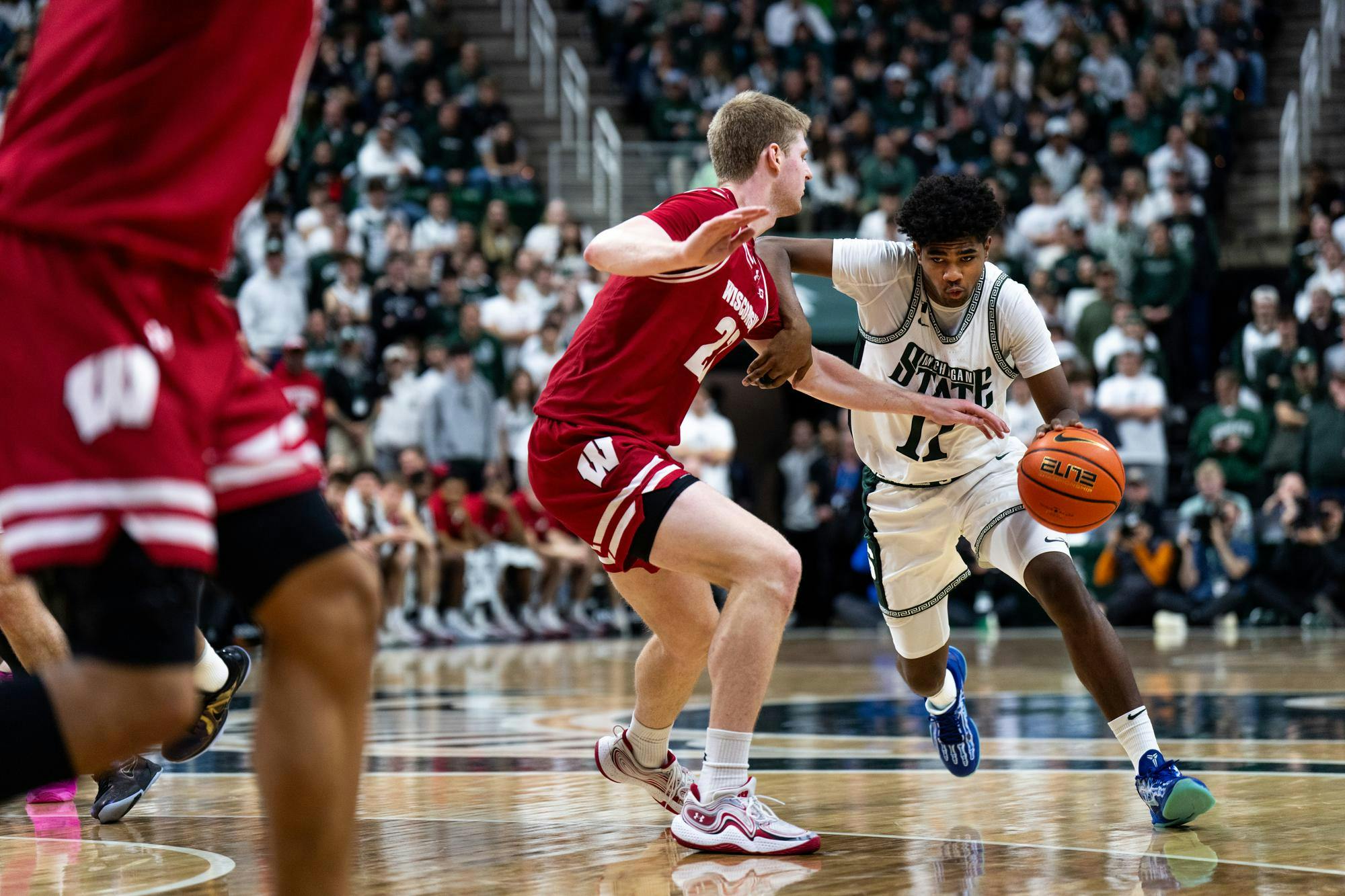 Michigan State freshman guard Jase Richardson (11) drives the paint while being defended by Wisconsin graduate forward Steven Crowl (22) at the Breslin Center on March 2, 2025. The Spartans went on to clinch a 71-62 victory over the Badgers.