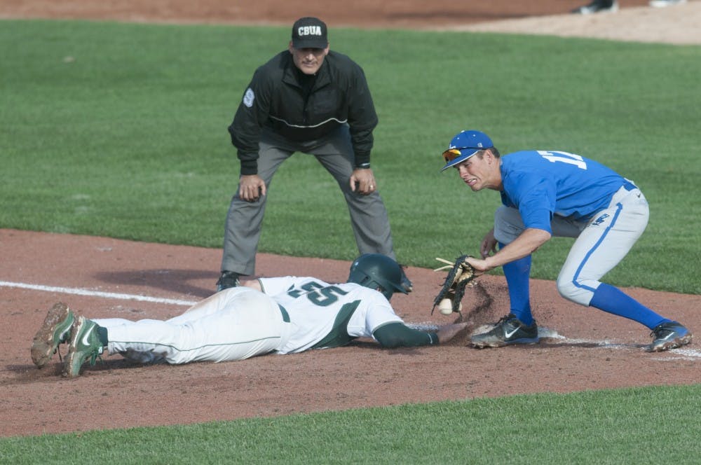 <p>Sophomore outfielder Zack McGuire dives to safety while Air Force infielder Shaun Mize attempts a catch during the baseball exhibition game against Air Force  on Sept. 19, 2015 at McLane Stadium. MSU baseball season begins in February. Jack Stephan/The State News</p>