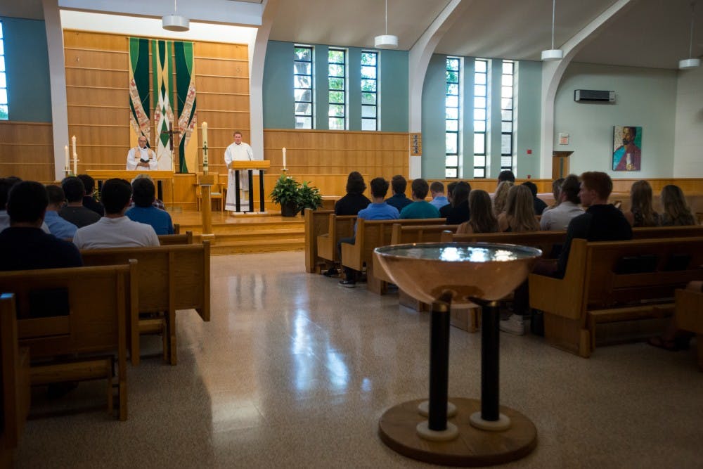The Rev. John Huber, left, and the Rev. Ryan Riley, right, stand at the altar during the prayer service in memory of MSU student Mitchel Kiefer on Sept. 20, 2016 at St. John Church and Student Center at 327 M.A.C. Ave. Friends gathered together in memory of Mitchel Kiefer after he was involved in a fatal car accident the day before. 