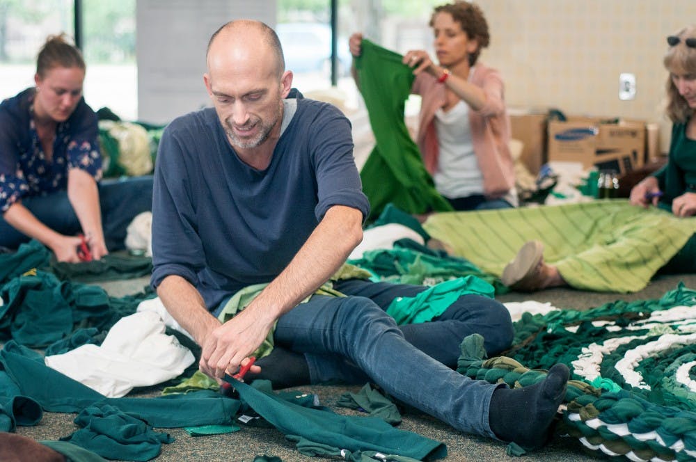 Los Angeles and artist Fritz Haeg crochets a rug as part of his "Domestic Integrities" project on Monday evening, Sept. 17, 2012 at the former Barnes and Noble in downtown East Lansing. Old clothes, sheets and pieces of cloth were gathered to be woven into the rug. Natalie Kolb/The State News