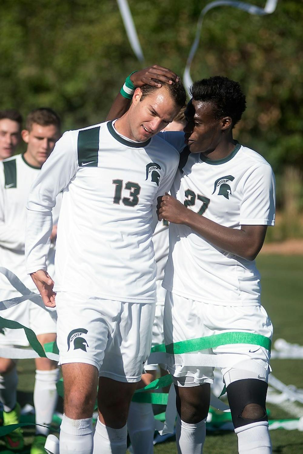 <p>Senior forward Fatai Alashe celebrates with senior forward Adam Montague after Montague scored a goal during the game against Michigan on Nov. 2, 2014, at DeMartin Stadium at Old College Field. The Spartans lost, 3-2. Julia Nagy/The State News</p>