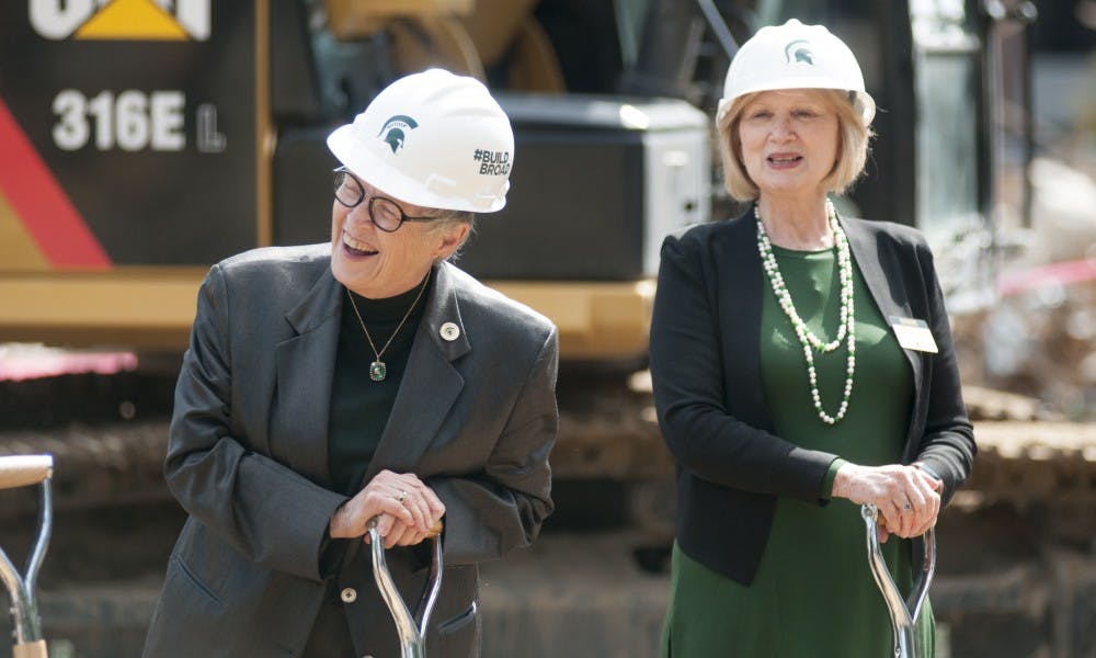 <p>President Lou Anna K. Simon, left, and Provost June Youatt, right, enjoy a moment during the groundbreaking ceremony for the Broad College of Business Pavilion Project on Sep. 8, 2017 across from the Red Cedar River outside the Broad College Complex. Following the ceremony, a reception took place for the donors and other attendees.&nbsp;</p>
