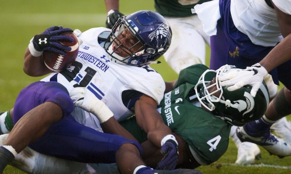 Junior defensive tackle Malik McDowell (4) tackles Northwestern running back Justin Jackson (21) during the game against Northwestern on Oct. 15, 2016 at Spartan Stadium. The Spartans were defeated by the Wildcats, 54-40.