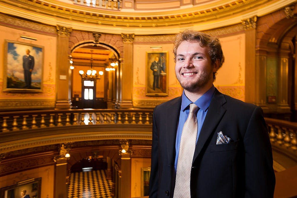 <p>Social relations and policy and comparative cultures and politics senior Ryan Miller poses for a portrait, August 1, 2014, at the Michigan State Capitol. Miller is interning with the Michigan House of Representatives. Corey Damocles/The State News </p>