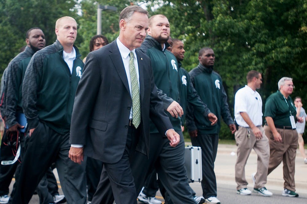 	<p>Football head coach Mark Dantonio leads his team on Red Cedar Rd. on Aug. 30, 2013, outside of Spartan Stadium. The Spartans defeated the Broncos, 26-13. Katie Stiefel/The State News</p>
