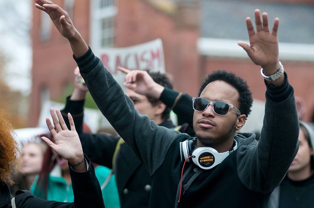 <p>Supply chain management sophomore Steve Cleaves-Jones holds his hands up to support the "Hands up, don't shoot" movement on Oct. 22, 2014, near Olin Health Center. Protesters marched to the police department from the Beaumont Tower to support Michael Brown, who was shot and killed by police in Ferguson, Mo. Aerika Williams/The State News</p>