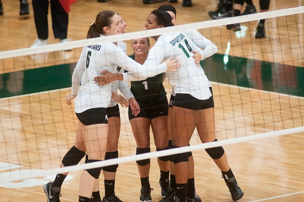 	<p>Freshman Allyssah Fitterer, left, juniors Kori Moster, center, and Jazmine White, right, congratulate each other and their teammates on a play Oct. 5, 2013, at Jenison Field house. <span class="caps">MSU</span> defeated Northwestern in the first three matches. Margaux Forster/The State News</p>