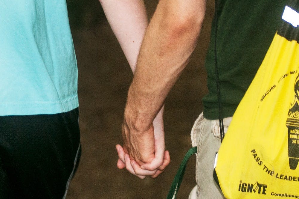	<p>Lansing resident and <span class="caps">MSU</span> alumnus Justin Love, left, and genomics and molecular genetics senior Zachary DeRade, right, hold hands during a nature walk, July 26, 2013, at Fitzgerald Park, 133 Fitzgerald Park Drive, in Grand Ledge, Mich. The couple enjoys the nature trails of the park in addition to the disc golf course. Danyelle Morrow/The State News</p>
