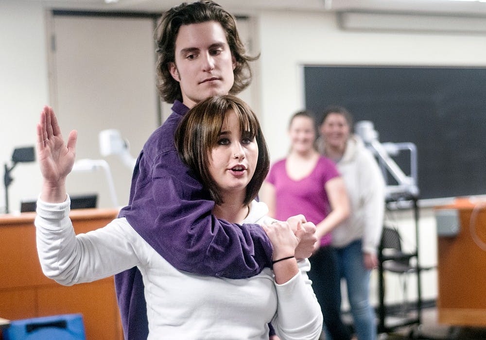 	<p>Psychology and social work sophomore Emily Koehler instructs students on proper self-defense technique as hospitality business junior Gavin Hoppe demonstrates a scenario Wednesday, Jan. 30, 2013, at Snyder Hall. Students came to the self-defense workshop to learn how to help protect themselves against dangerous situations. Adam Toolin/The State News</p>