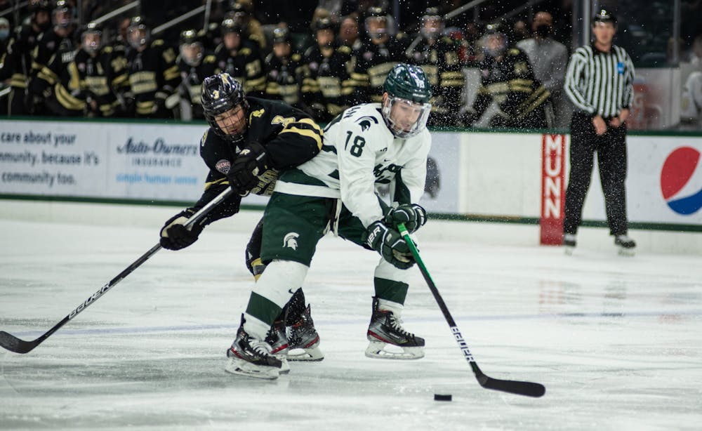 <p>Spartan wing Griffin Loughran (18) and Bronco Michael Joyaux (3) chase the puck in MSU&#x27;s match against Western at Munn Ice Arena on Wednesday, Dec. 29, 2021.  </p>