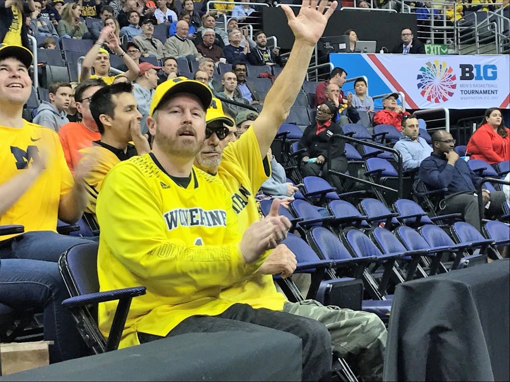 <p>Jeremy Janssen (left) and his father Jim Janssen (right) cheer for a made basket at the Verizon Center in Washington D.C. They were able to experience the Big Ten Tournament because it is located on the east coast this year.&nbsp;</p>