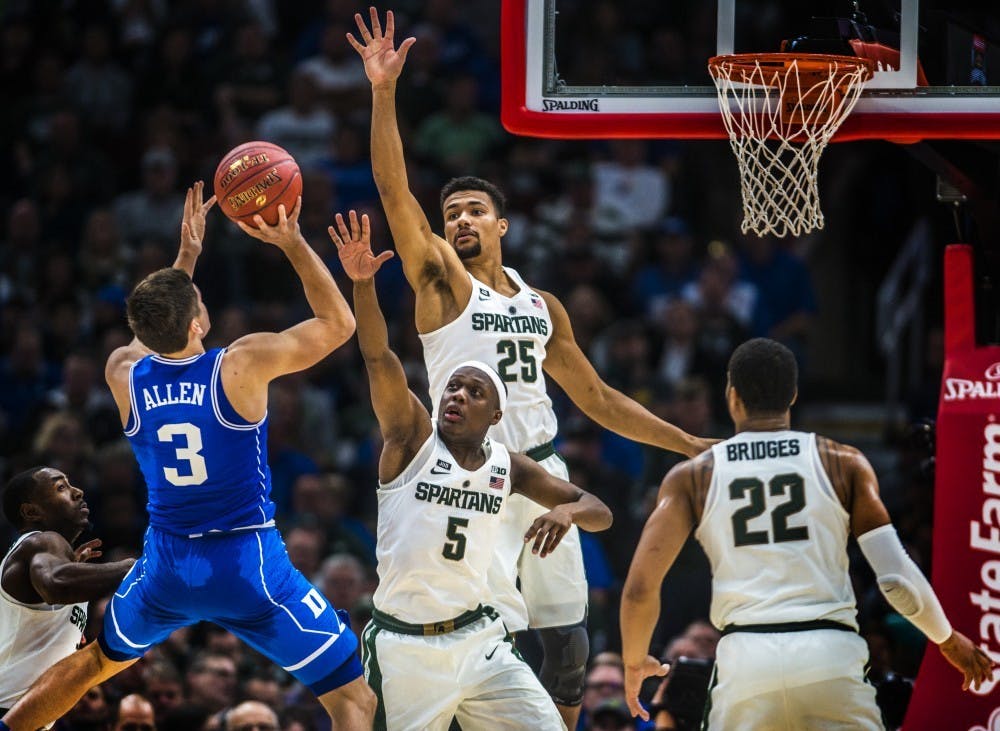 <p>Duke guard Grayson Allen (3) attempts to shoot a basket as sophomore guard Cassius Winston (5) and redshirt junior forward Kenny Goins (25) attempt to block during the Champions Classic during the game against Duke on Nov. 14, 2017 at the United Center. The Spartans were defeated by the Blue Devils, 81-88.&nbsp;</p>