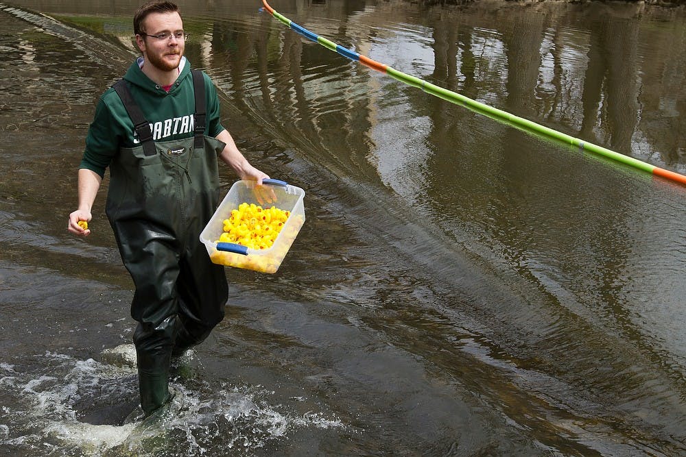 <p>Premedical and marketing junior Tristan Worthington heads to shore with the winning duck after the Duck Race  April 25, 2015, in front of Wells Hall. Simon Schuster/The State News</p>