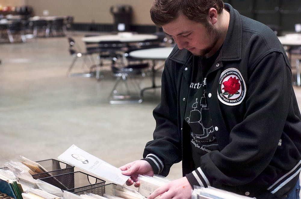 <p>History freshman Jacob McCormick browses through papers searching for local historical programs at the 59th Michigan Antiquarian Book & Paper Show on April 6, 2014, at the Lansing Center. The show is put on by the owner of Curious Books Shop on Grand River Avenue. Emily Jenks/The State News</p>