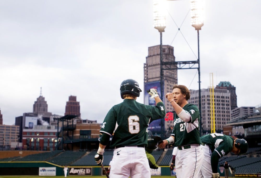 	<p>Senior first baseman Jeff Holm bumps fists with sophomore left fielder Jordan Keur after scoring a run Wednesday at Comerica Park in Detroit. The Spartans defeated Central Michigan, 3-1, in the Clash at Comerica. Matt Radick/The State News</p>