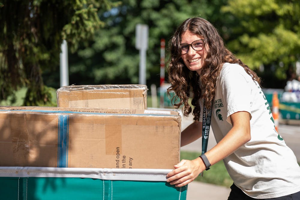 <p>An MSU student pushes a cart full of items during fall move-in at Yakeley Hall in East Lansing, Mich., on Aug. 25, 2026.</p>