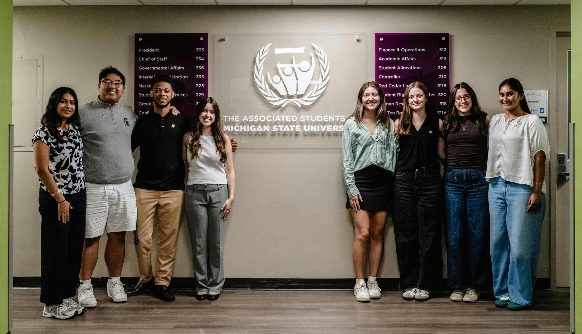 ASMSU office members stand in from of the ASMSU sign in their lobby in East Lansing, Michigan on Sept. 12, 2025.