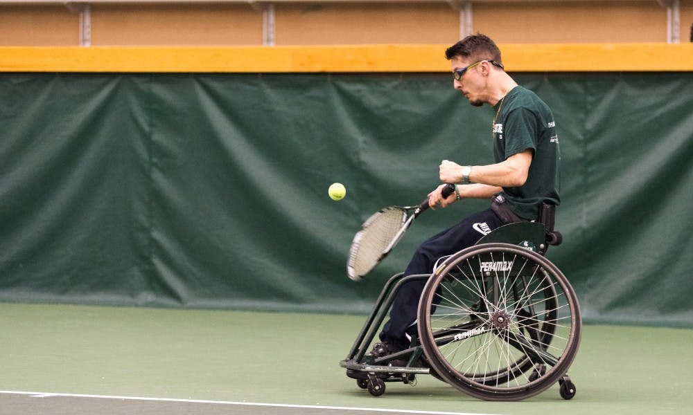 Graduate student Piotr Pasik swings at the ball during a wheelchair tennis practice on April 5, 2017 at the Indoor Tennis Facility at 3571 East Mount Hope Ave in Lansing. The MSU men's tennis head coach Gene Orlando was honored with the U.S. Tennis Association's Brad Parks award for his contributions to wheelchair tennis at MSU.