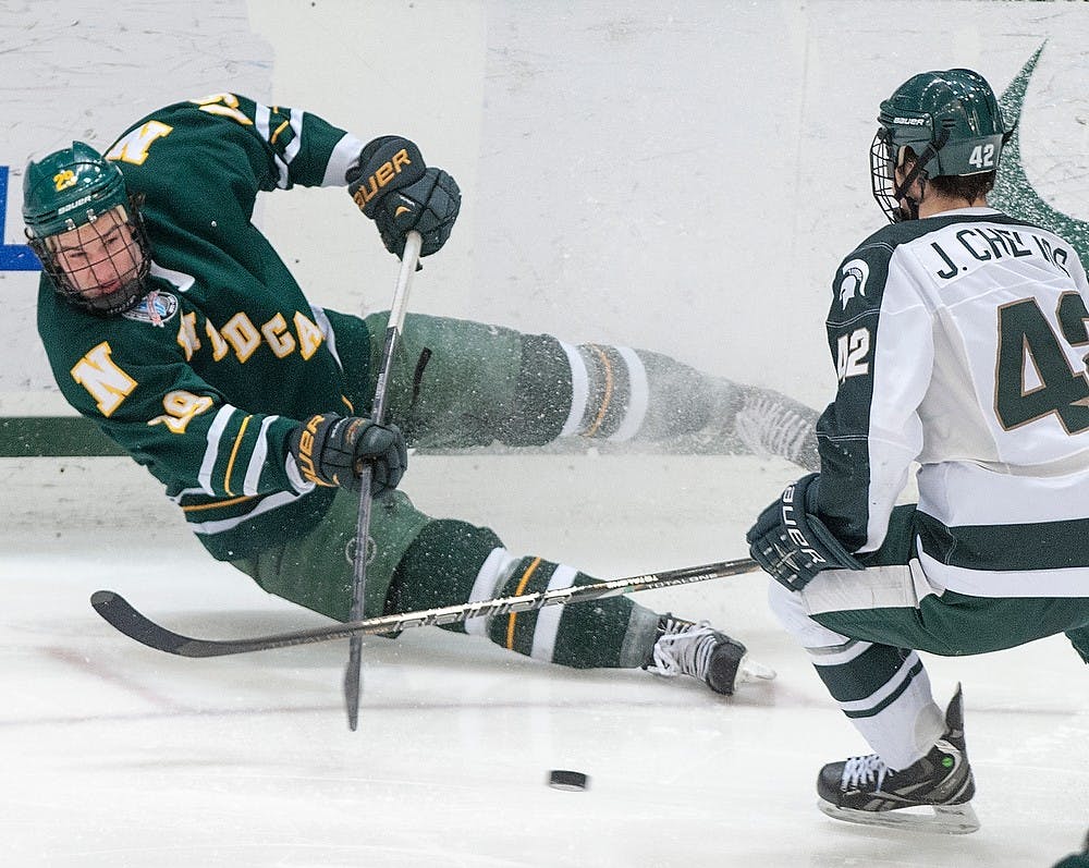 	<p>Northern Michigan forward Kory Kaunisto tries to shoot past junior defenseman Jake Chelios. The Spartans defeated the Wildcats, 4-2, Saturday, Feb. 16, 2013, at Munn Ice Arena. Justin Wan/The State News</p>