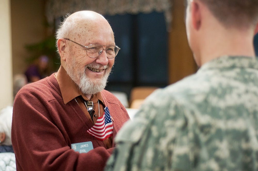 	<p>East Lansing resident James Dyal speaks with Army <span class="caps">ROTC</span> cadet and political science freshman Richard Maher during a Veterans Day ceremony Nov. 11, 2013, at Burcham Hills Retirement Community, 2700 Burcham Dr. Cadets and veterans were given American flag pins and certificates during a ceremony thanking them for their service. Danyelle Morrow/The State News</p>