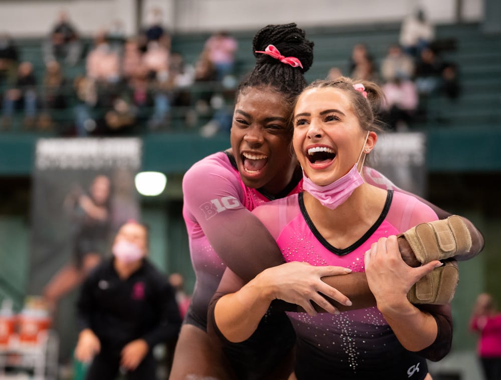 <p>Freshman Gabrielle Stephen embraces senior Sydney Ewing for her 99 after her floor routine at the Spartans&#x27; match against the University of Iowa Hawkeyes at Jenison Field House on Saturday, Jan. 22, 2022. </p>