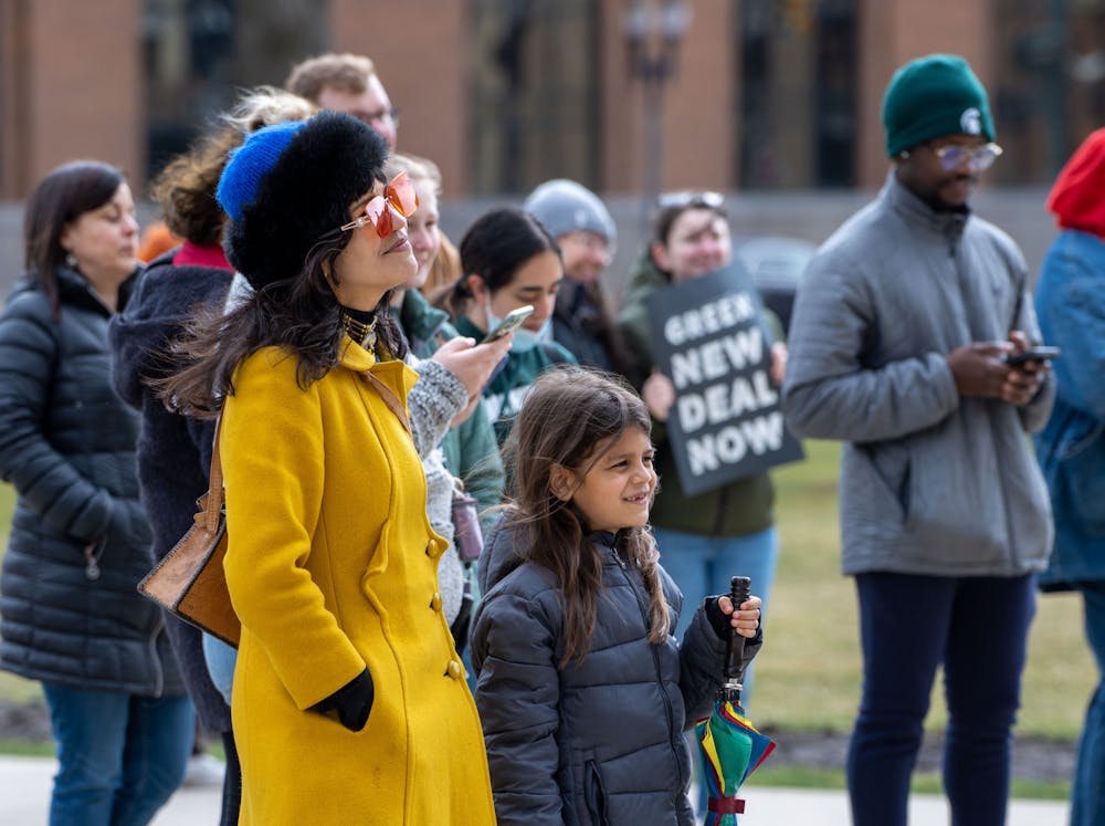 A mother and her child listen to the speakers during the Friday for Futures Event in Lansing on March 25th, 2022.