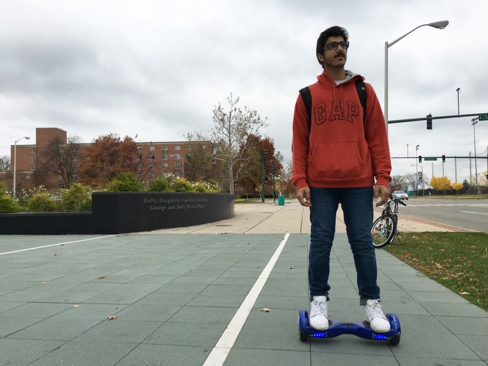 <p>Business freshman Abdullah Alhalabi rides his hoverboard to class on Oct. 30, 2015 at the intersection of West Shaw Lane and Chestnut Road.</p>