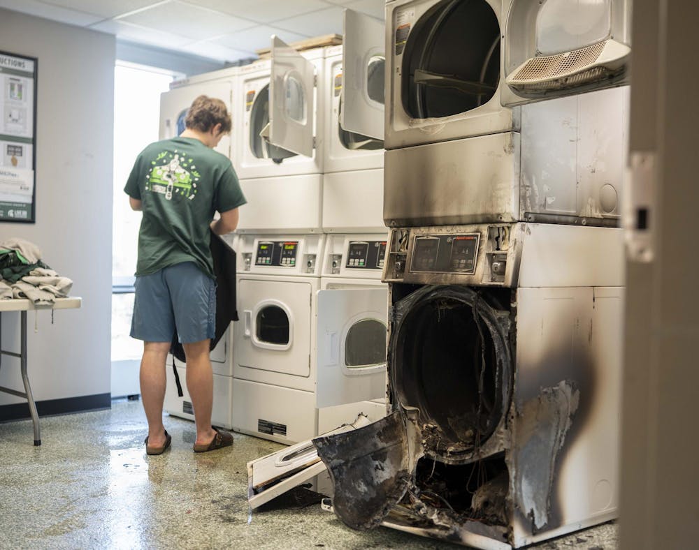 <p>A student unloads his laundry after a dryer fire on the third floor of Butterfield Hall on March 19, 2025. MSU Student Life and Engagement staff were at the scene to help residents retrieve their laundry before closing the room for cleaning.</p>