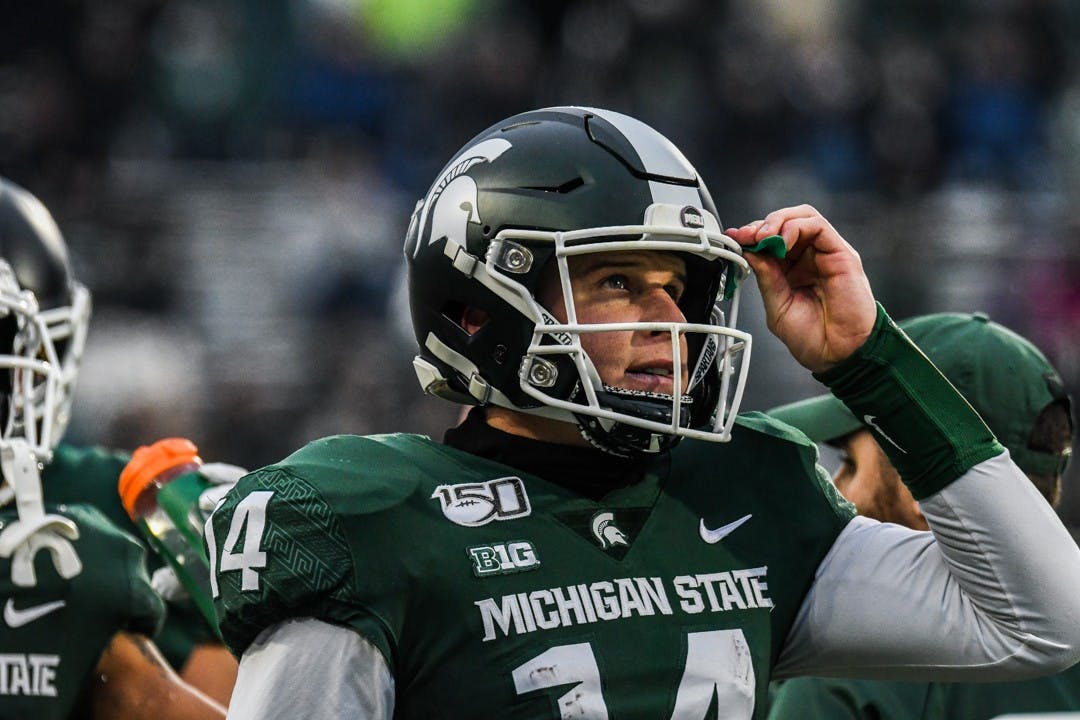 Senior quarterback Brian Lewerke (14) looks at the scoreboard during the game on Nov. 30, 2019 at Spartan Stadium. The Spartans lead 13-7 against the Terrapins at halftime.