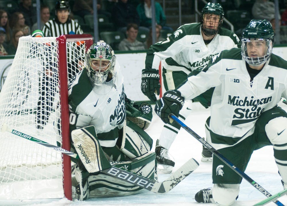 <p>From left to right, senior goaltender Jake Hildebrand, senior defenseman John Draeger and sophomore defenseman Travis Walsh watch the puck during the first period of the game against New Hampshire on Nov. 7, 2015, at Munn Ice Arena. The Spartans defeated the Wildcats, 7-4. </p>