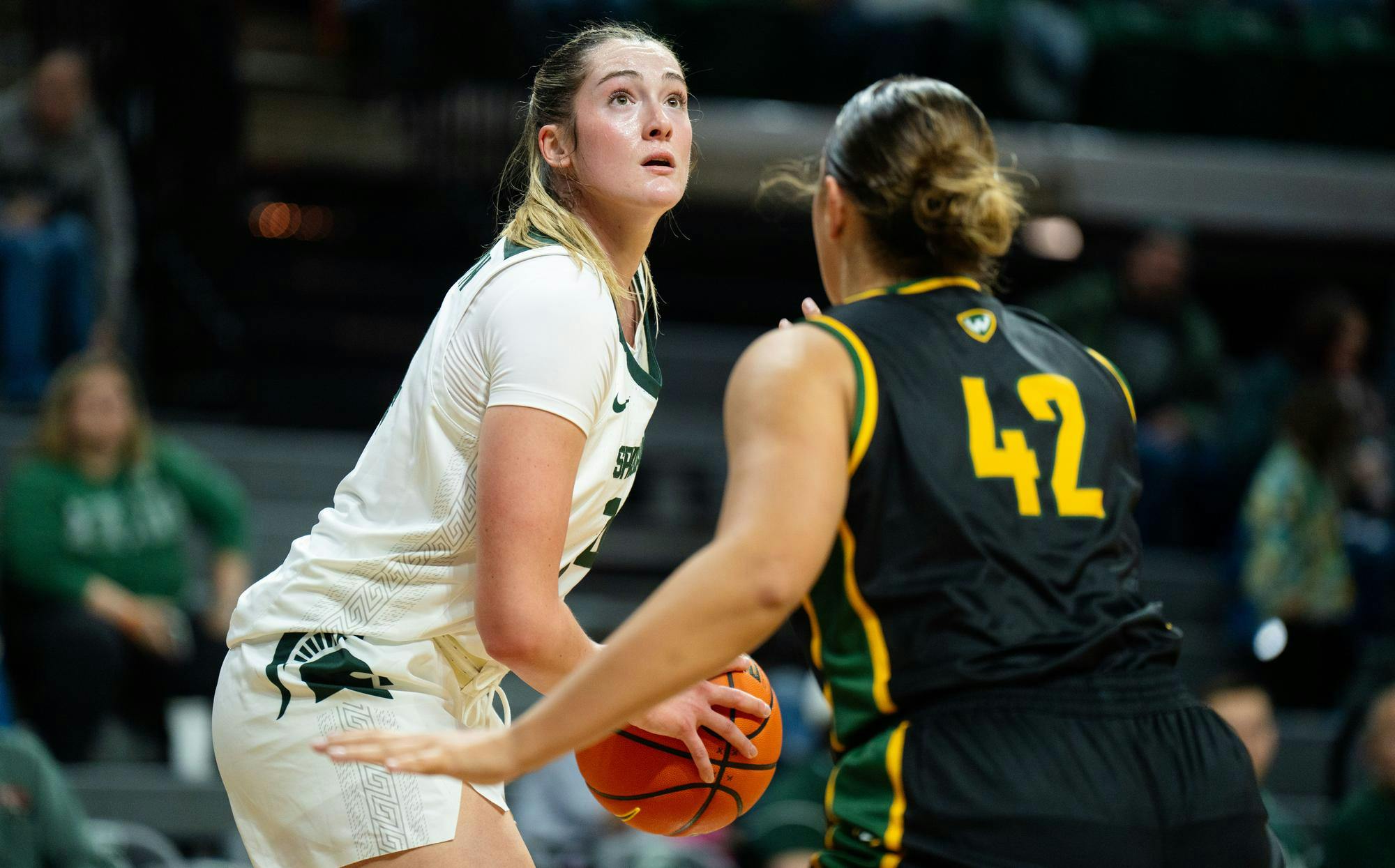 <p>Michigan State University junior forward Grace VanSlooten looks to throw the ball while being guarded by Wayne State University junior forward Mackenzie Miller (42) in the Breslin Student Events Center on Oct. 28, 2024. The Spartans beat the Warriors, 101-40.</p>