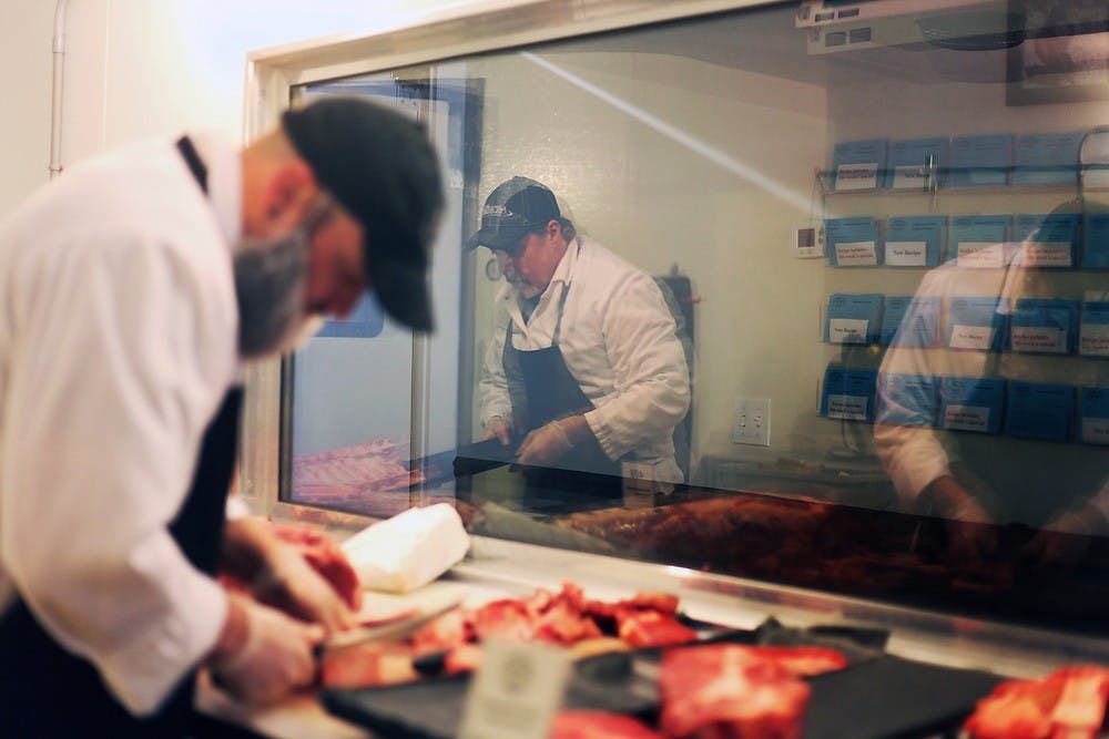 <p>Jackson, Mich., resident Al Steele, left, and Lansing resident Chris Badour cut meat May 16, 2014, at Mert&#8217;s Specialty Meats, 1870 W. Grand River Ave., in Okemos. The store employs and serves many <span class="caps">MSU</span> students and staff members, including women&#8217;s basketball head coach Suzy Merchant and athletic director Mark Hollis, said owner and operator Shirley Becker Prescott. Danyelle Morrow/The State News</p>