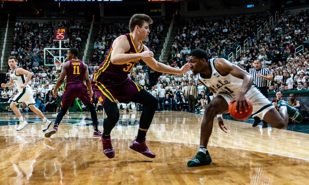 <p>Freshman forward Aaron Henry (11) drives on Minnesota's Brock Stull. MSU beat Minnesota 79-55 at the Breslin Center on Feb. 9, 2019.</p>