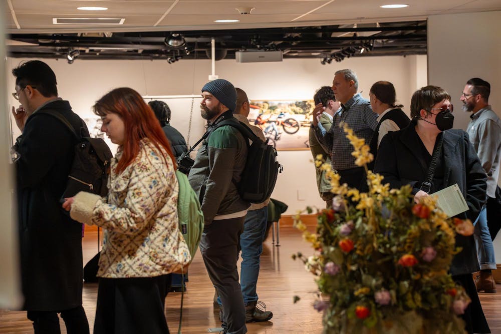 Attendees gather to have books signed, converse and enjoy refreshments during the second half of the Residential College in the Arts and Humanities’ event featuring poet Dennis Hinrichsen in East Lansing, Mich., on Feb. 25, 2026.