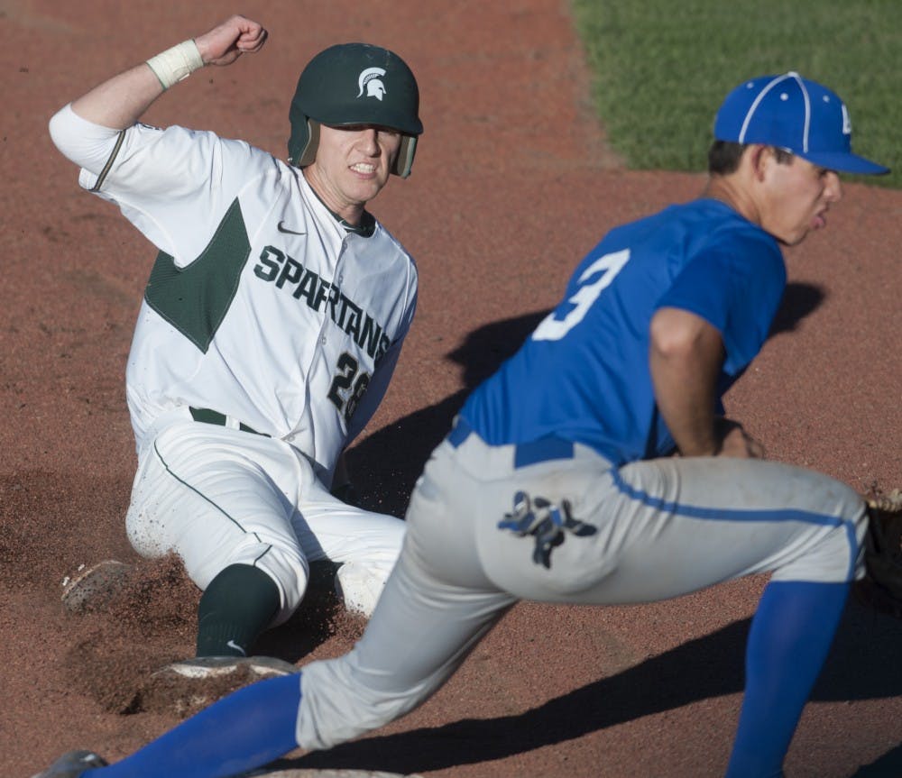 <p>Senior pitcher Jeff Kinley slides to third base while Air Force outfielder and catcher Benn Hawkins attempts to stop him during the baseball exhibition game against Air Force on Sept. 19, 2015 at McLane Stadium. MSU baseball season begins in February. Jack Stephan/The State News</p>