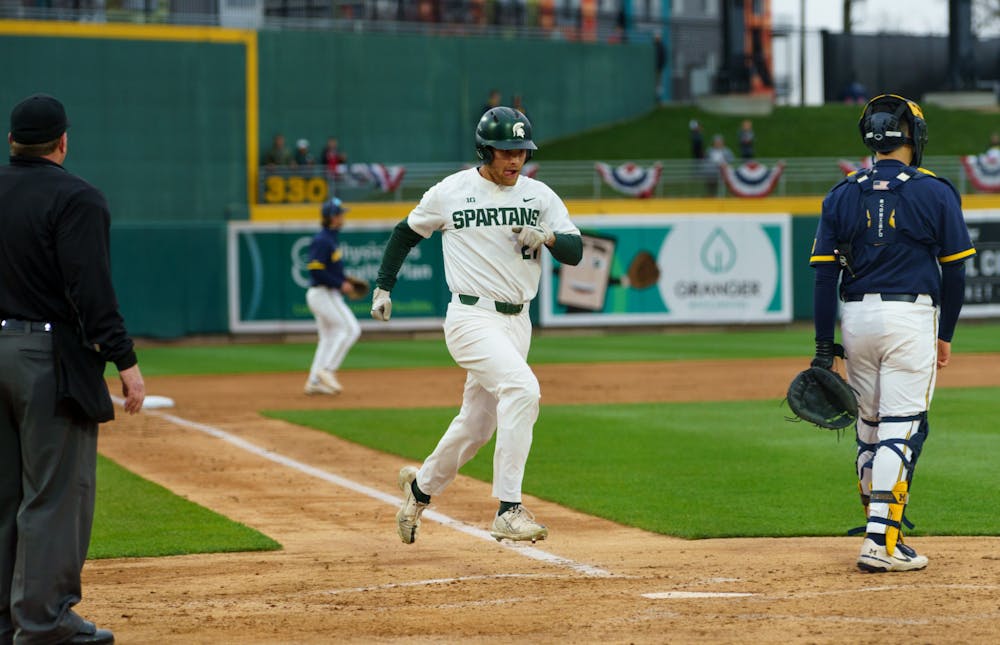 <p>Michigan State sophomore center field Jack Frank (21) runs home, scoring the second run for Michigan State in the bottom of the fourth. Michigan State lost 18-6 to Michigan on April 15, 2022, at the Lugnut Stadium.</p>