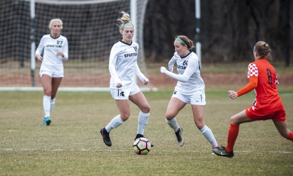 Freshman midfielder Sadie Misiewicz (24) attempts to dribble past Bowling Green defender Alexis Fricke (8) during the game against Bowling Green State University on March 25, 2017 at DeMartin Stadium. The Spartans defeated the Falcons, 5-1.